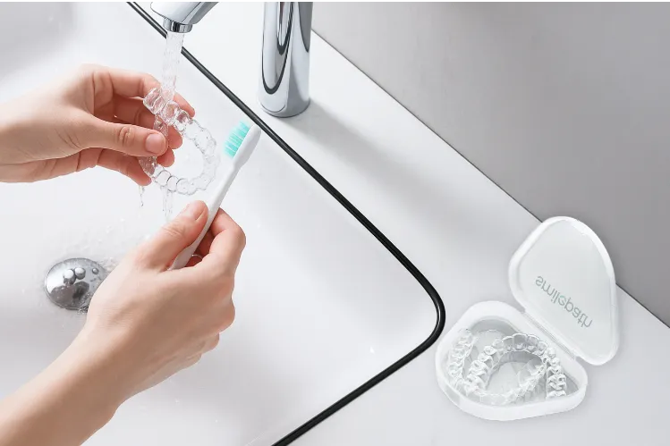 Aligner cleaning under running water with a soft-bristeld toothbrush