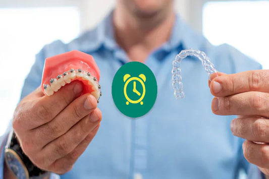 A man holding a tooth model with metal braces in one hand and a clear aligner in the other hand