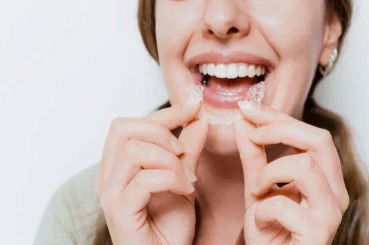 A woman wearing clear aligners.