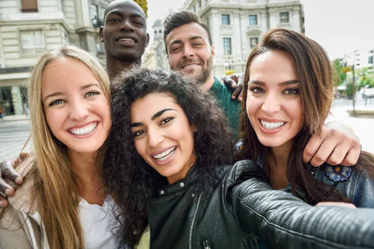 Group of five diverse friends smiling and taking a selfie together