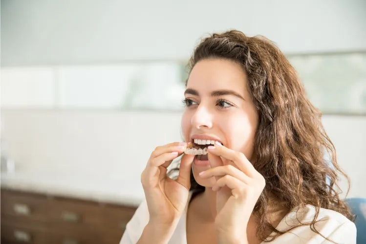  A girl applying teeth aligners without a dentist.