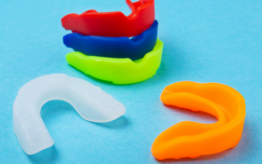 An image shows various colors of boxing mouth guards