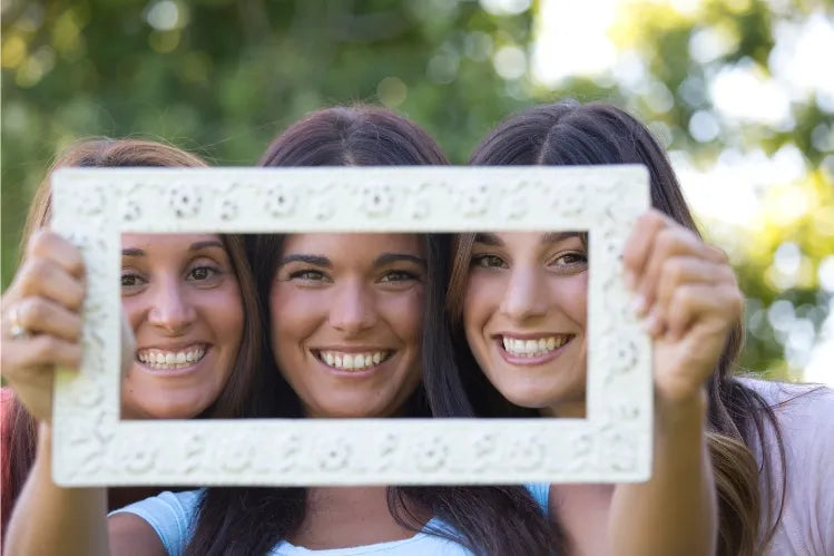 Smiling women with straight white teeth posing confidently, representing picture-perfect dental health