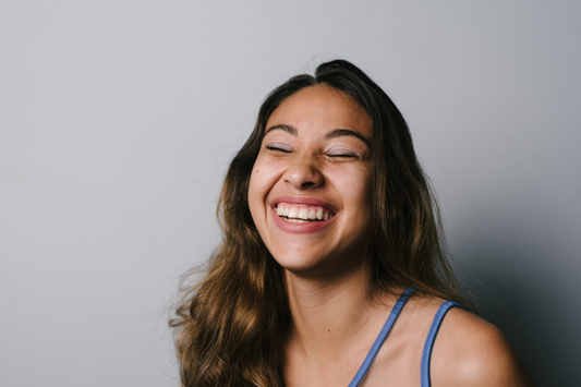 A girl confidently smiling while posing for a picture.