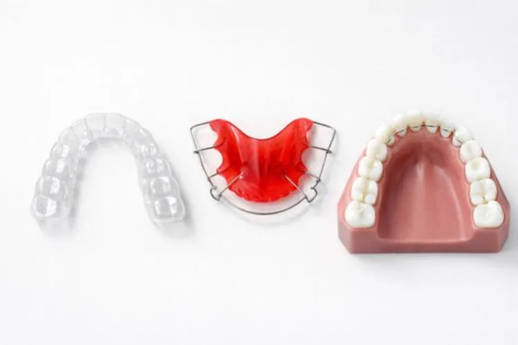 Three orthodontic retainers shown side by side: a clear retainer, a Hawley retainer, and a fixed bonded retainer