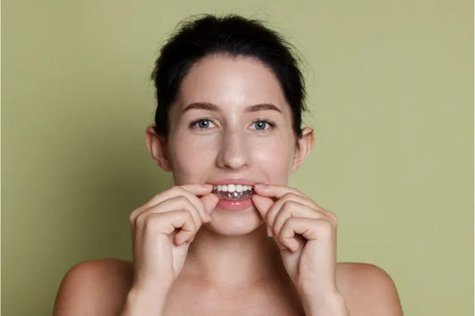Young woman putting on invisible braces for adults.