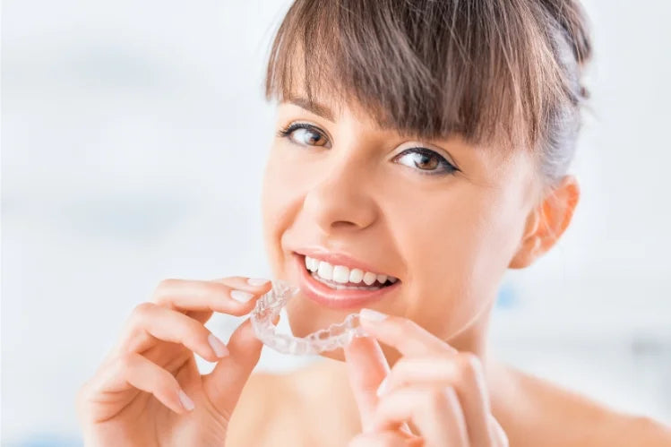 Woman holding a clear aligner