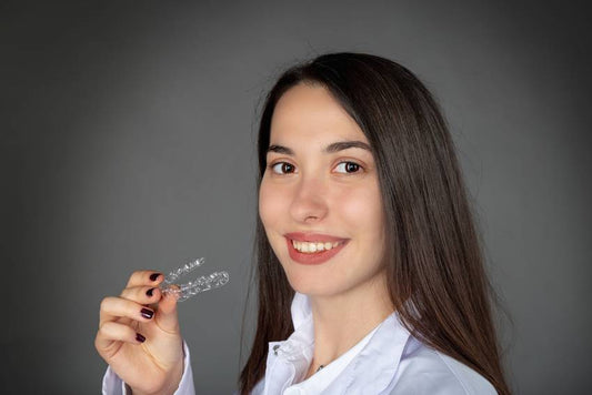 Beautiful-smiling-Turkish-girl-keeping-invisaligner-on-her-hand