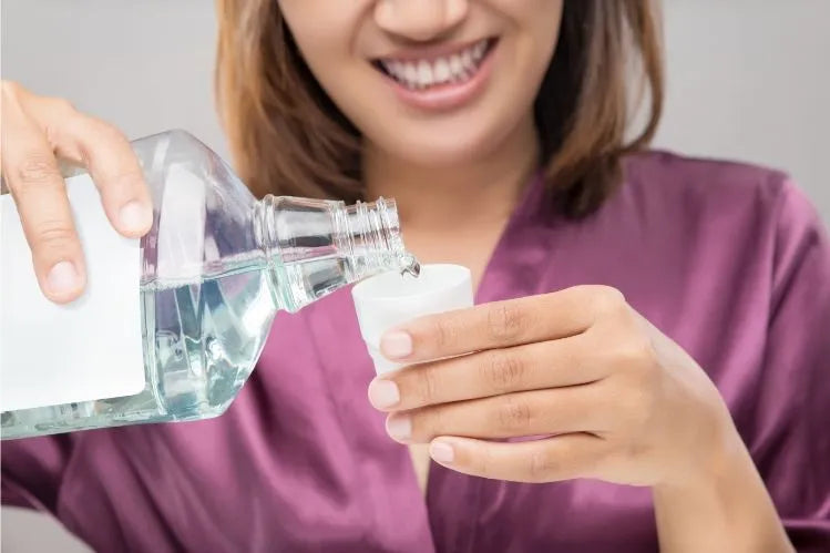 A girl is using mouthwash after brushng