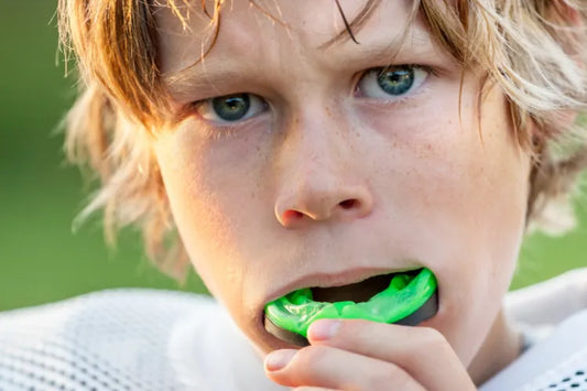 A sports dental mouthguard close-up, highlighted in green colour